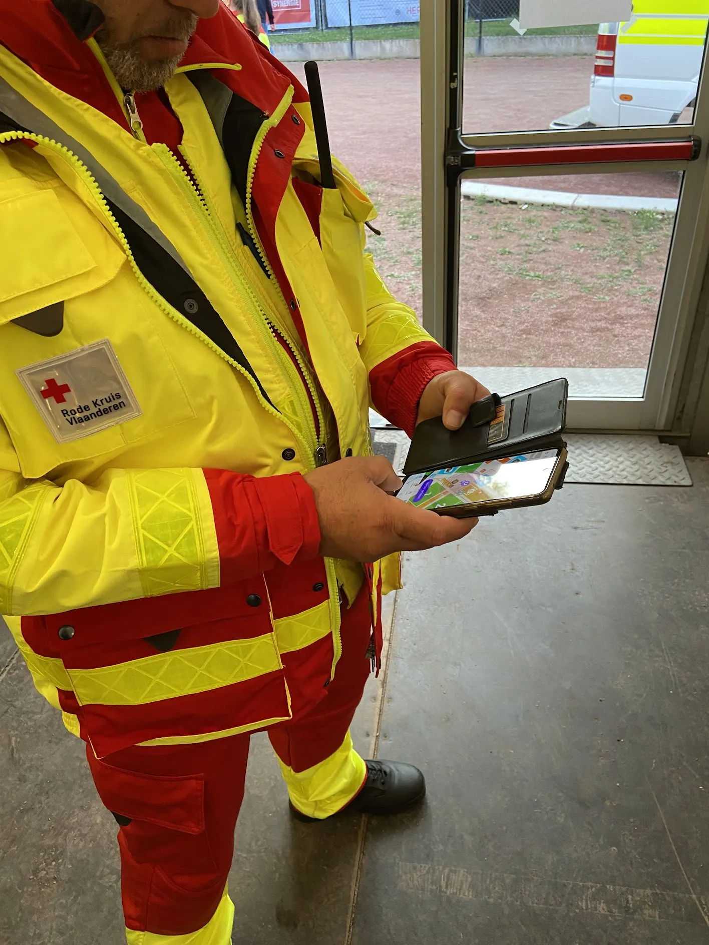 Rode Kruis Vlaanderen first-aid worker checking Festival Radar Pro on his phone